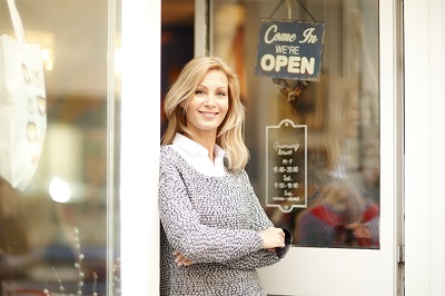 Portrait of designer woman standing in front of small vintage store